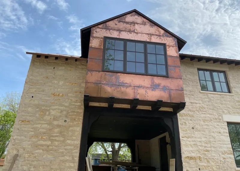 Copper metal panel facade on a stone building for Skylight Installation in Davenport